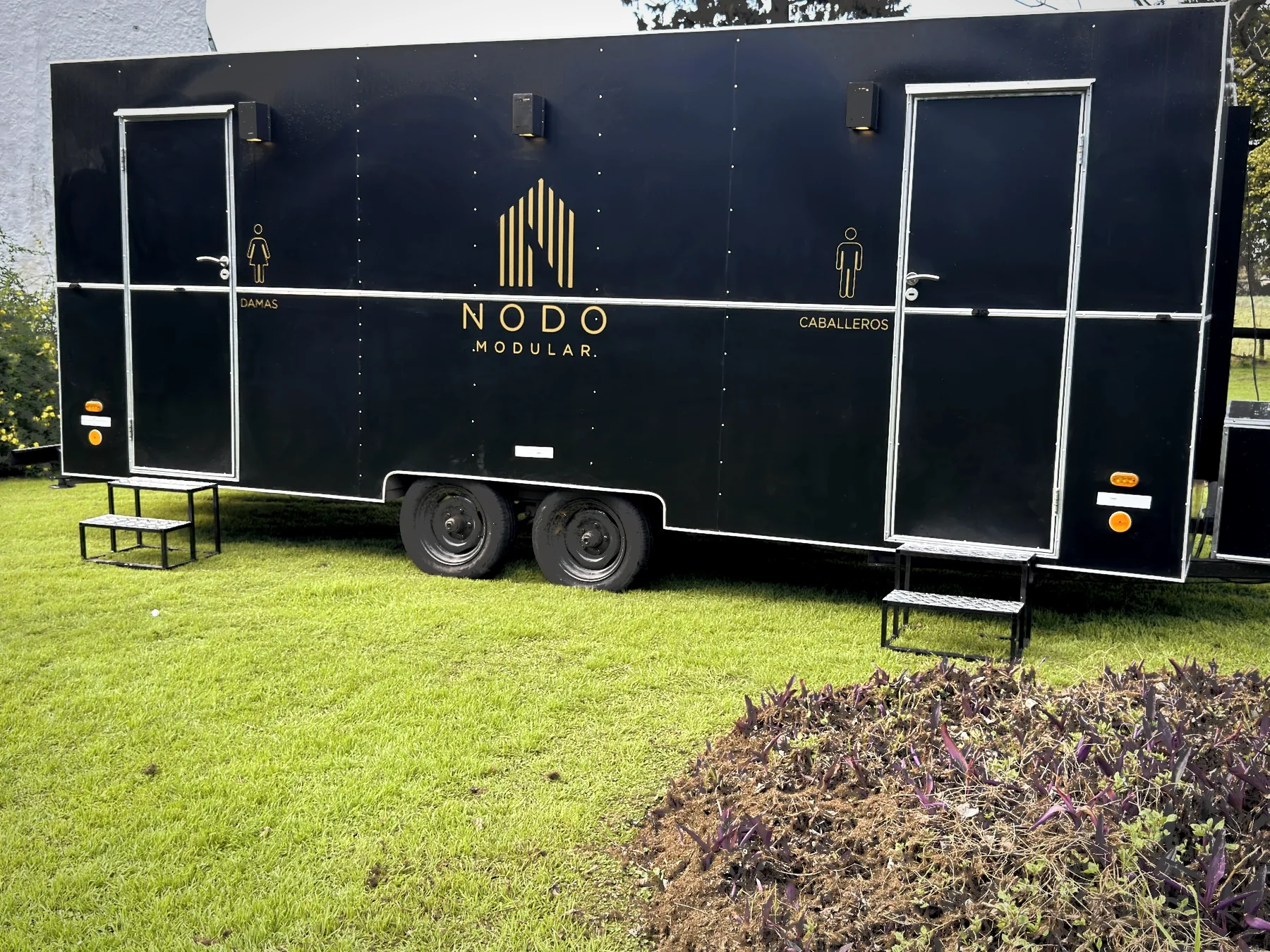 Lateral del trailer con los dos accesos, damas y caballeros, sobre el parque de la estancia.